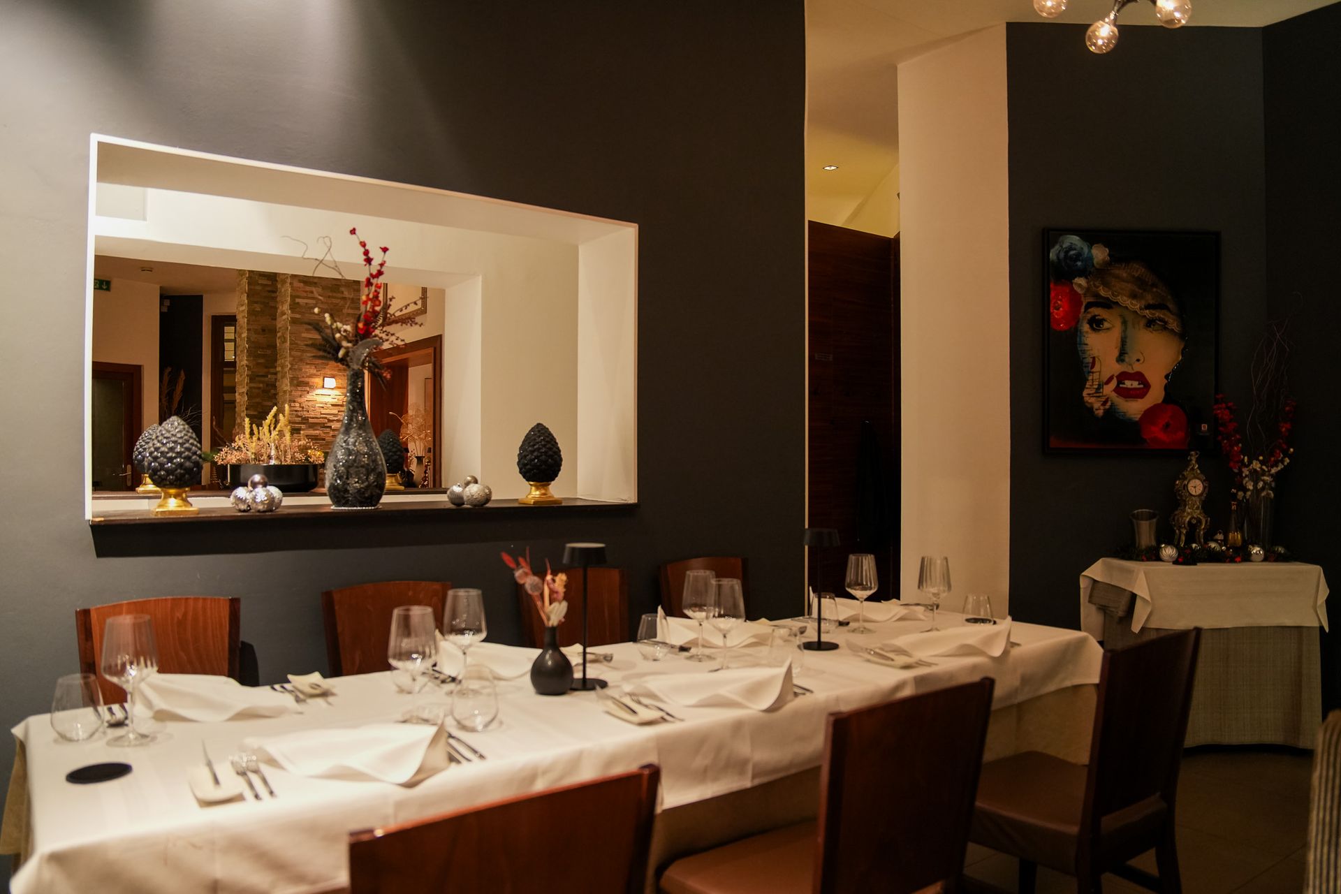 Innenraum des Restaurant Sorriso in Frankfurt-Sachsenhausen mit eingedecktem Tisch, Spiegel und dezenter Wandkunst
